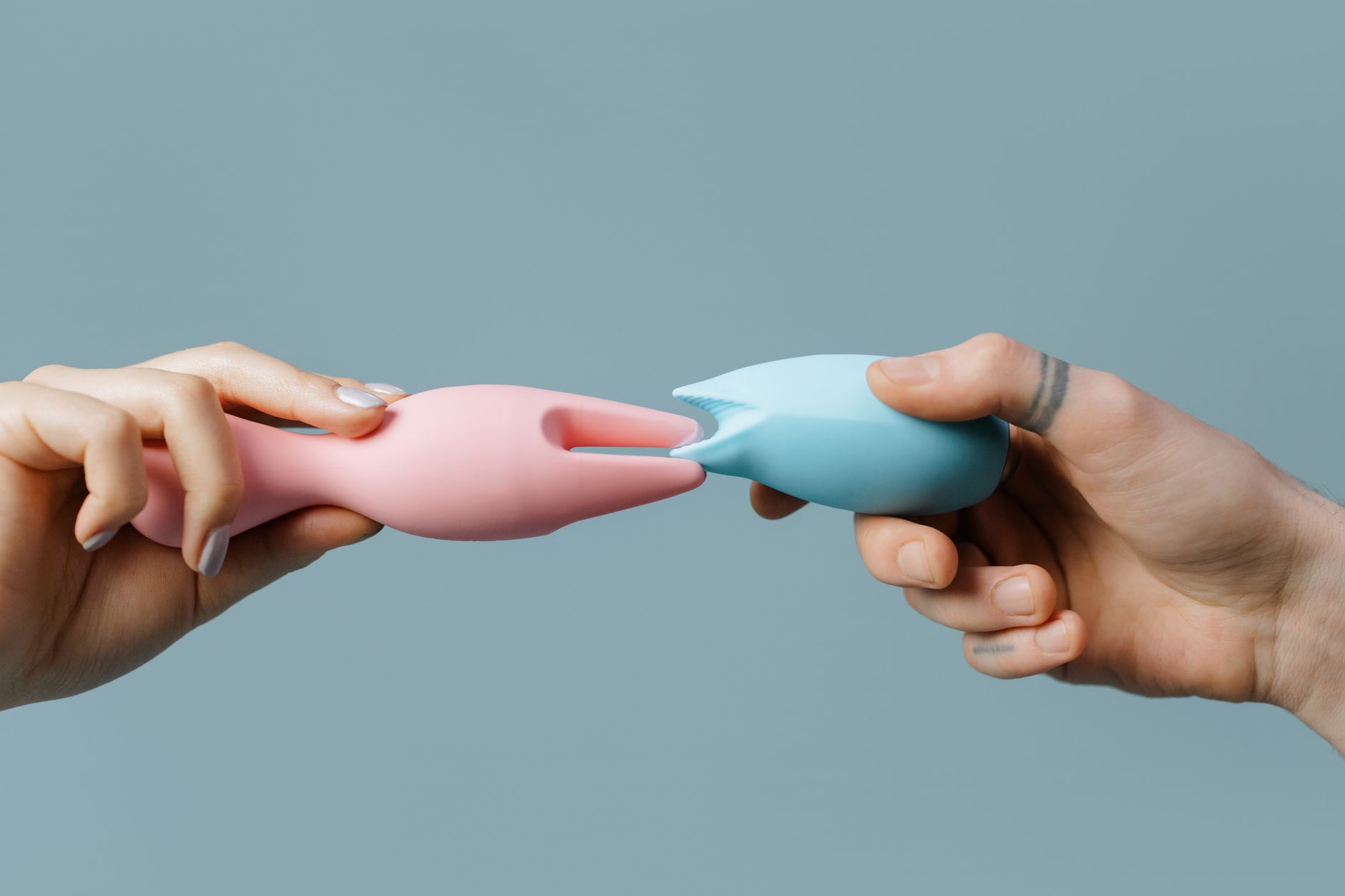 Hand holding a vibrator against a purple backdrop, showcasing modern sensuality